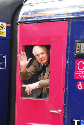 Oliver Lovell waving from a train door at Pershore Station