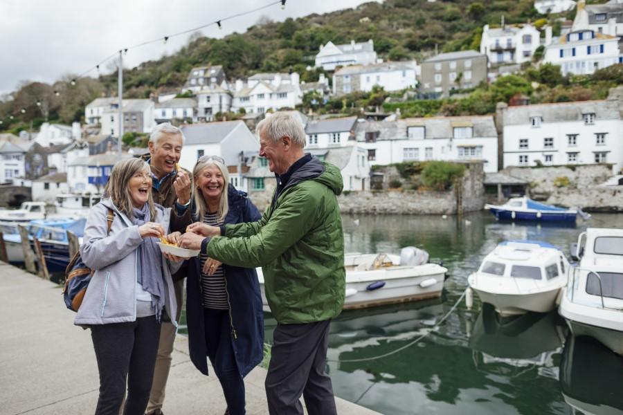 Four people enjoying fish and chips at a seaside town