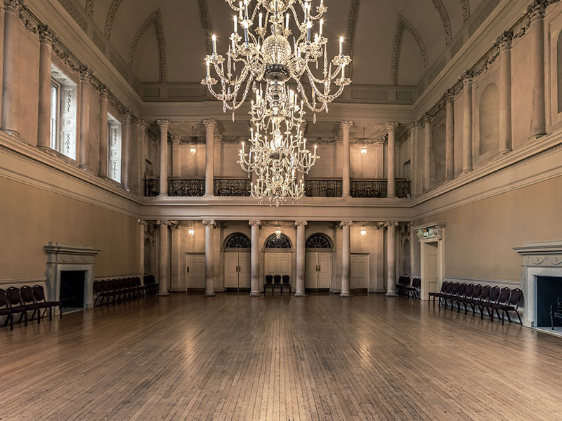 The tea room in Bath's Georgian era Assembly Rooms, with classical pillars and chandelier, used as a location in the Netflix series Bridgerton
