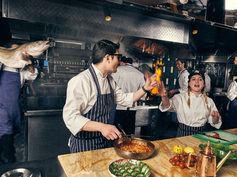 Kitchen staff prepare food in a lively London restaurant