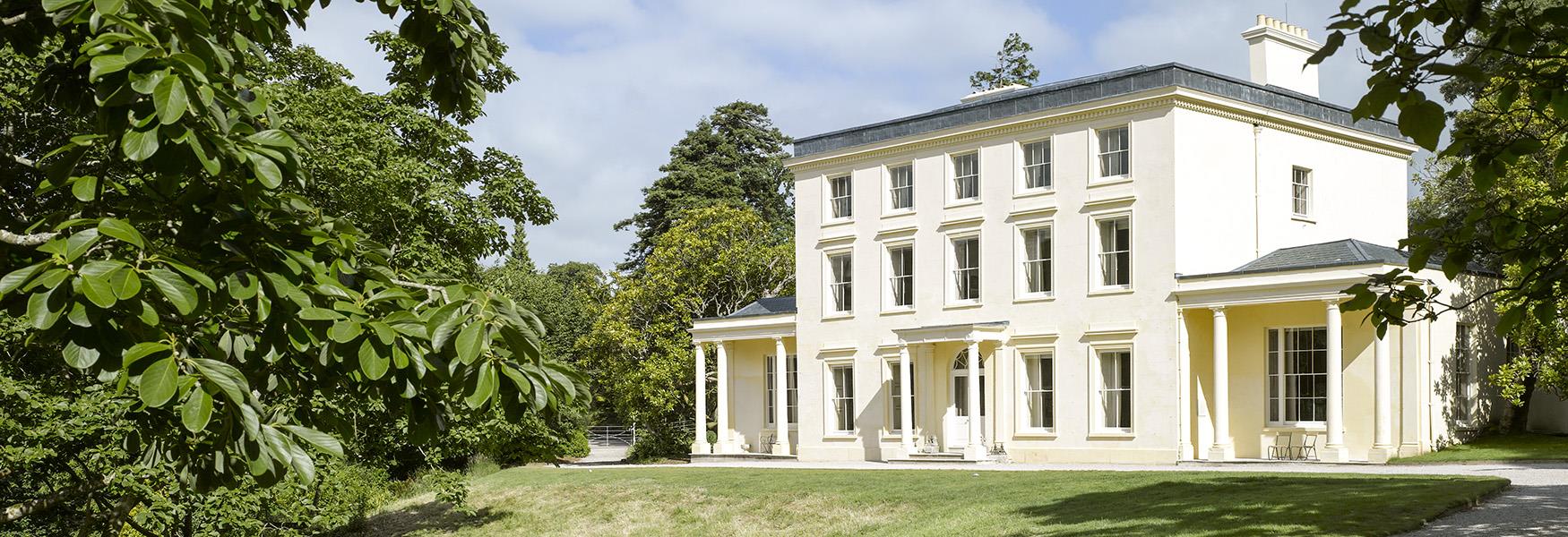 Exterior scenic image of a building with three floors, cream walls and multiple windows