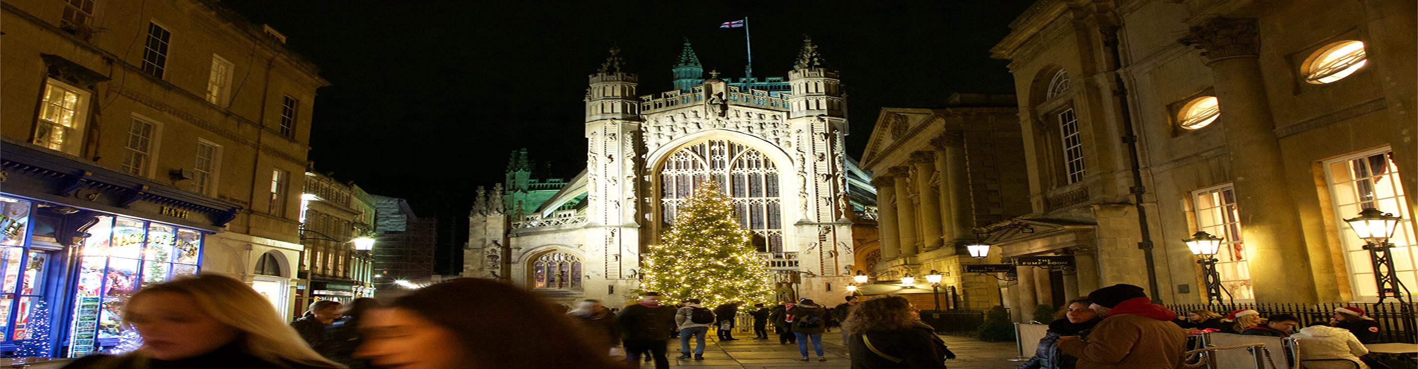 Shoppers in front of Bath Abbey during Christmas time at night