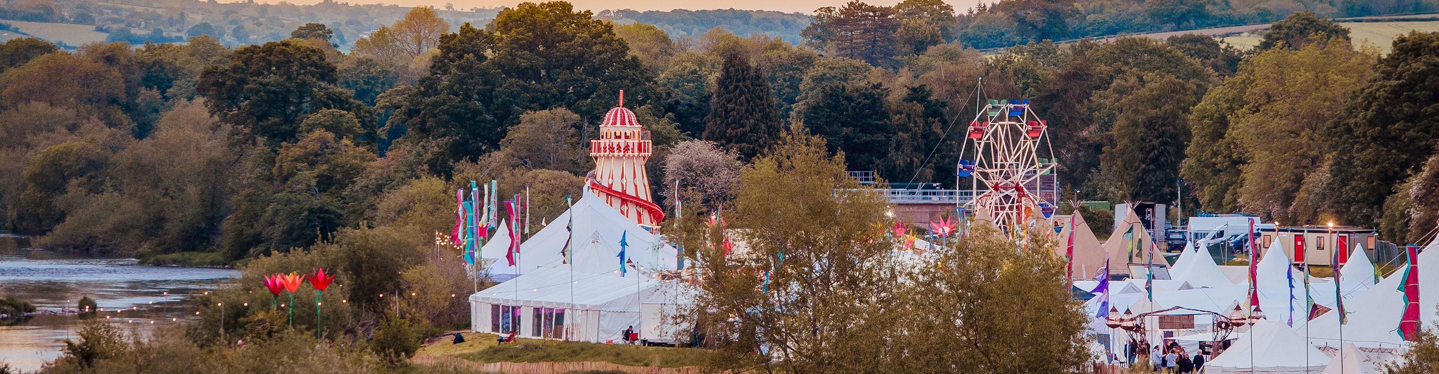 Festival marquees and rides overlooking the River Wye