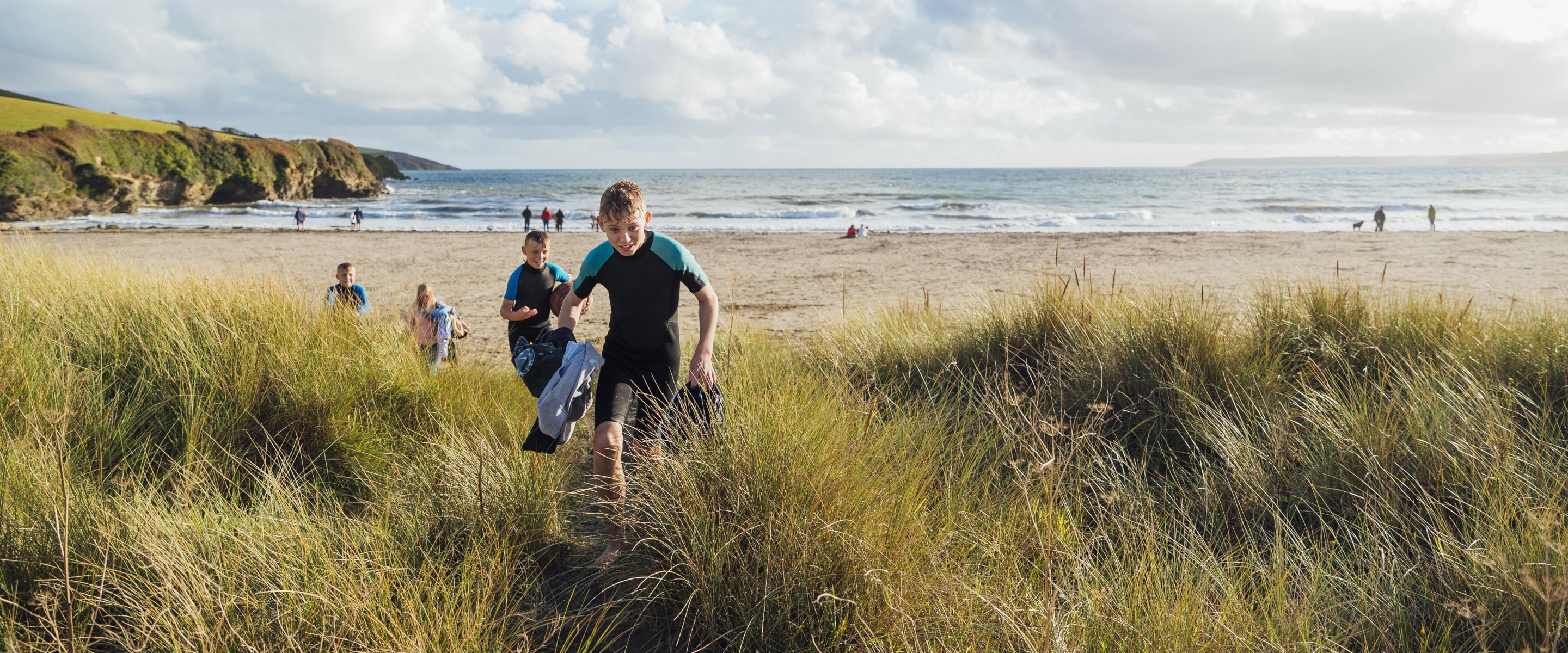 Photo of two young boys running off a beach