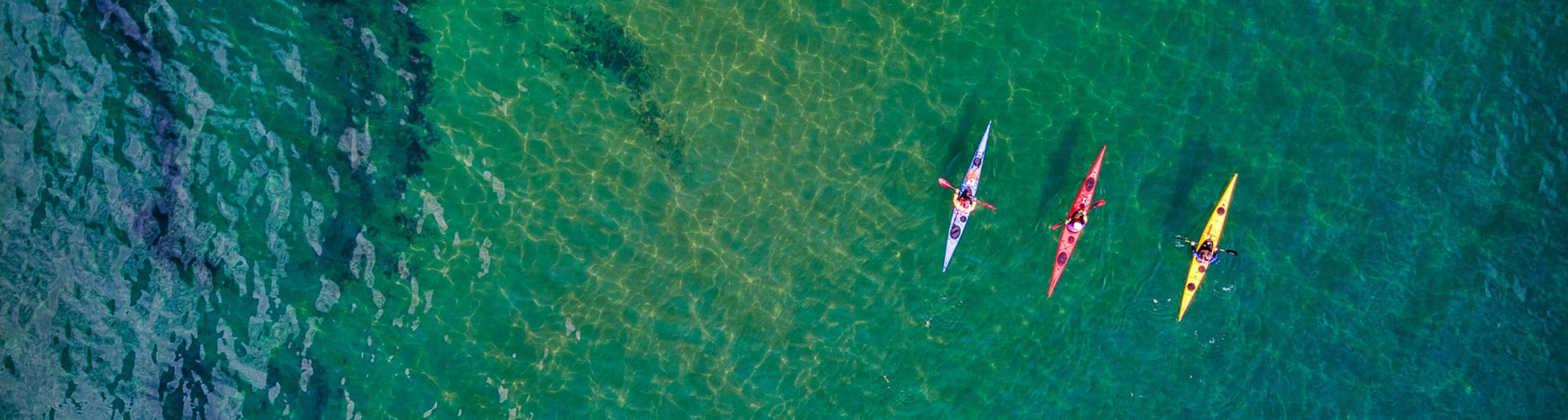 Three people kayaking on the Jurassic Coast