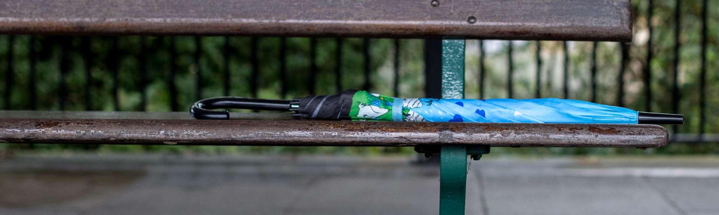 Lost umbrella left on a park bench