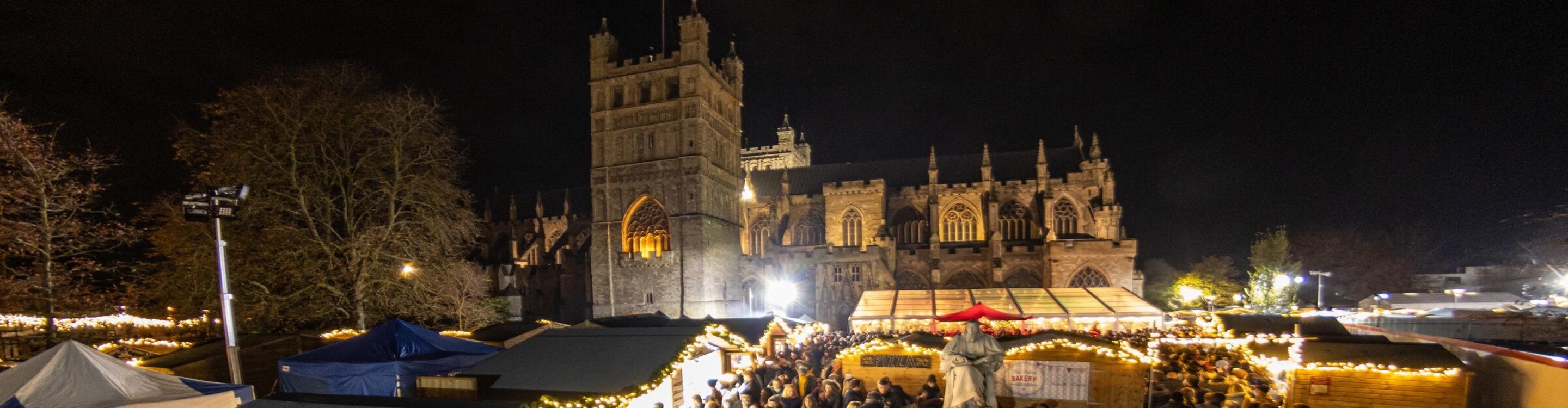 Christmas stalls set against the backdrop of Exeter Cathedral at night
