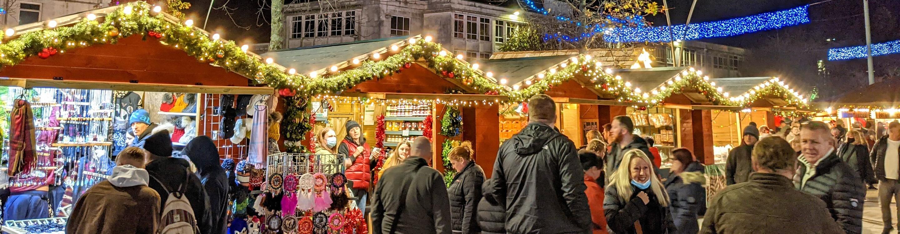 Crowds gathering outside Christmas stalls at the Plymouth Christmas Market