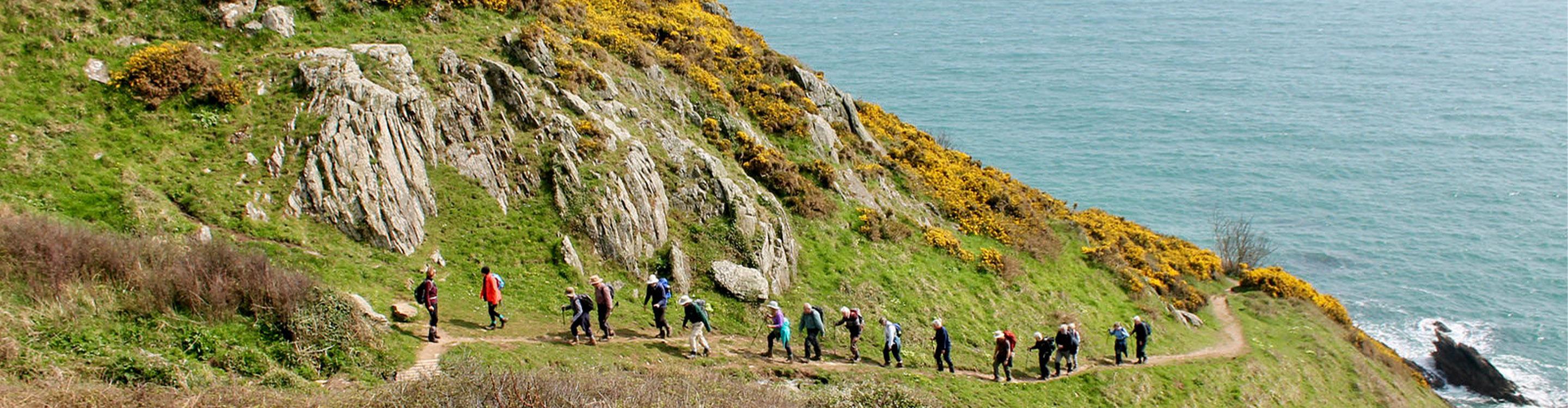 A group of people hiking through the South West Coast Path