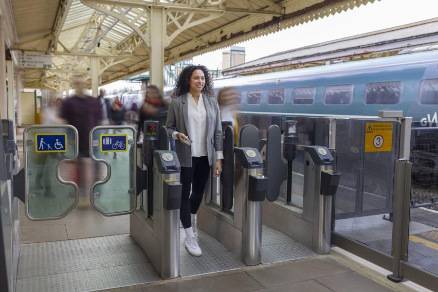 Customer going through a station gateline with ease, while other customers in the background are blurred and in motion