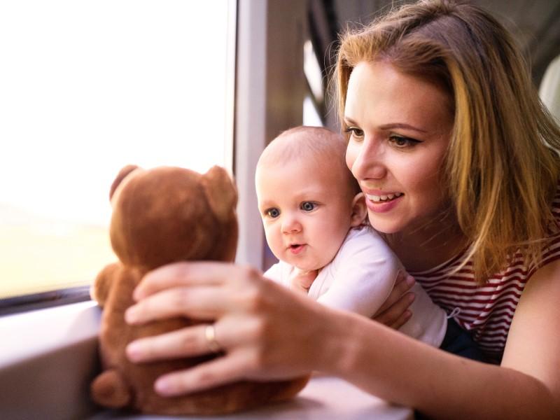 Mother with baby and a teddy bear on-board a train