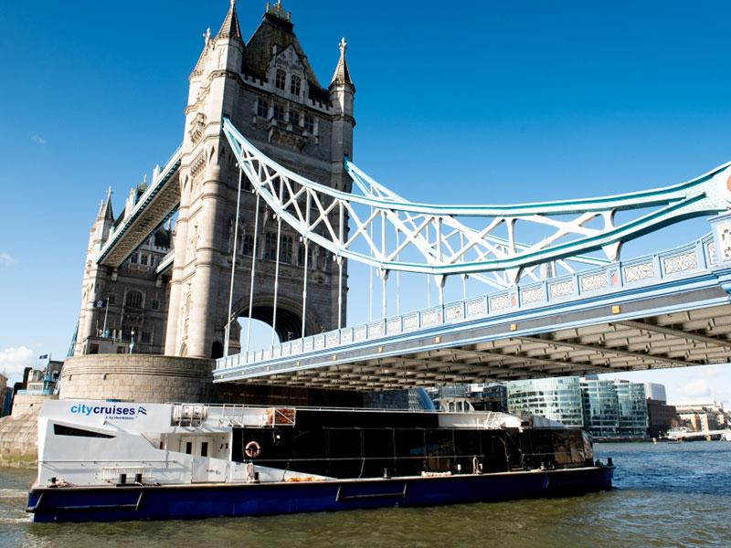 Photo of boat on the Thames going underneath Tower Bridge 