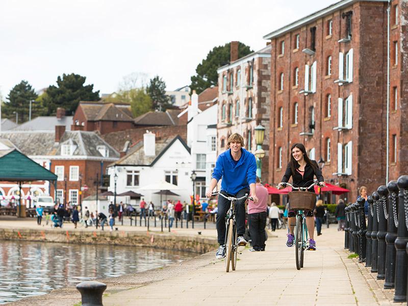 Couple cycling along the Exeter Quayside