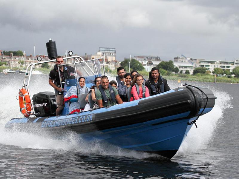 A speedboat full of passengers, travelling on Cardiff Bay, UK