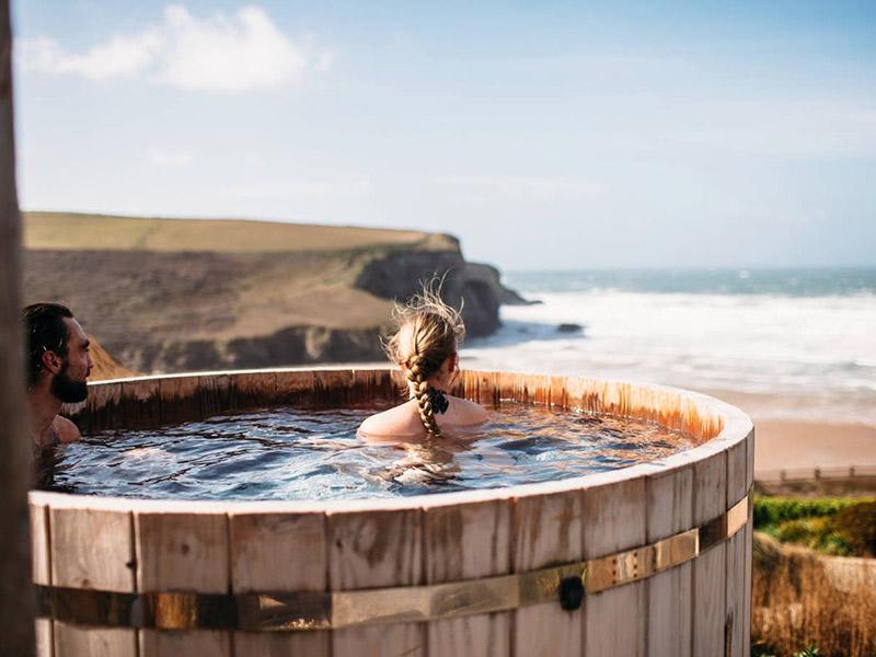 Couple in a hot tub at The Scarlet, Cornwall