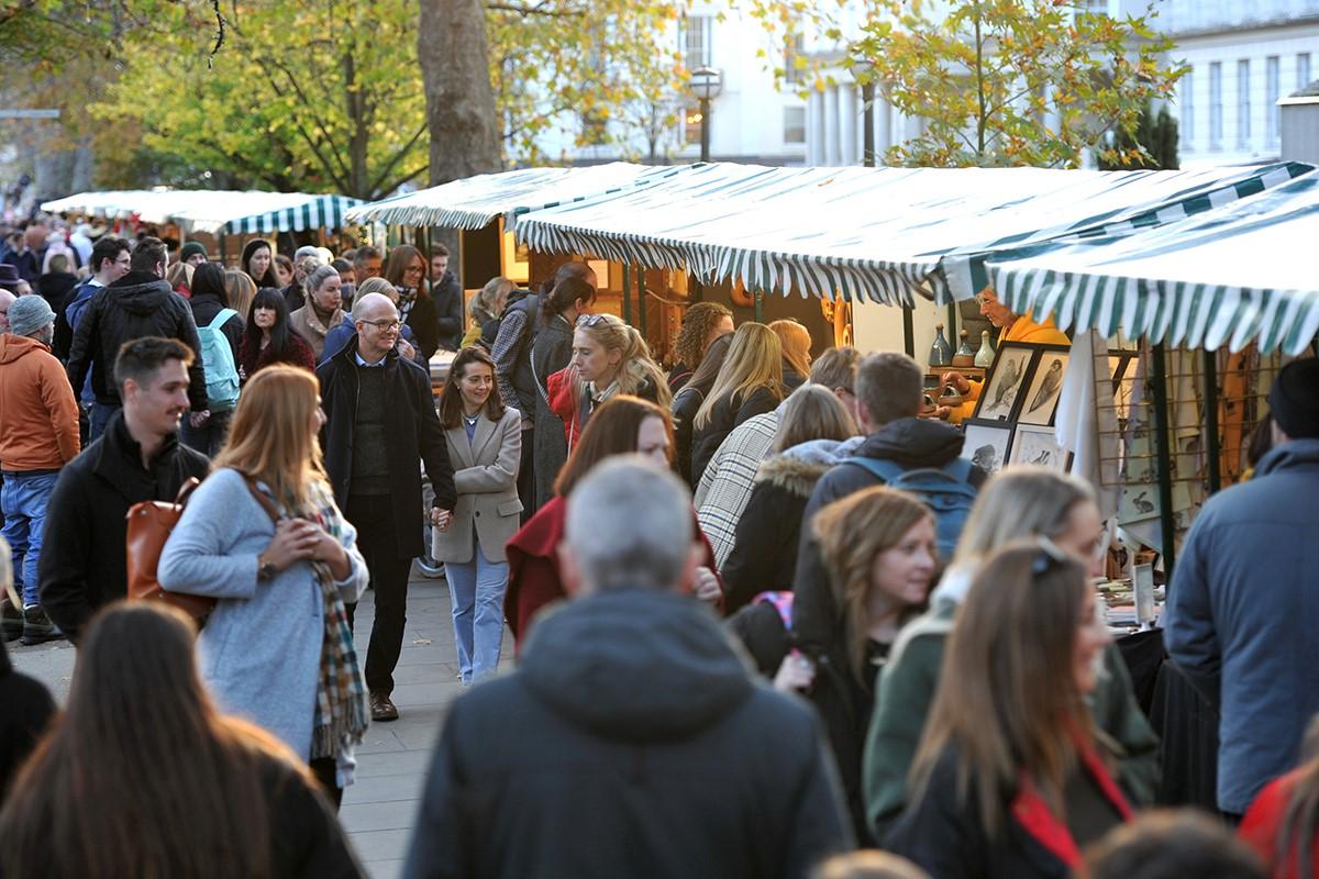 Crowds walking through Cheltenham Christmas Market in the day