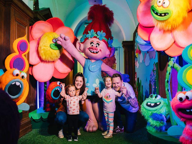 Family posing for a picture with characters at Shrek's World Adventure 
