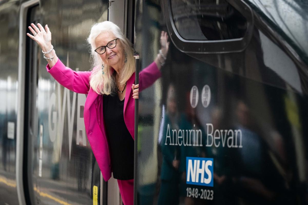 Aneira Thomas, the first baby born in the NHS, leans from the cabin of the newly named GWR train for Anuerin Bevan, the minister for health responsible for the launch of the NHS.