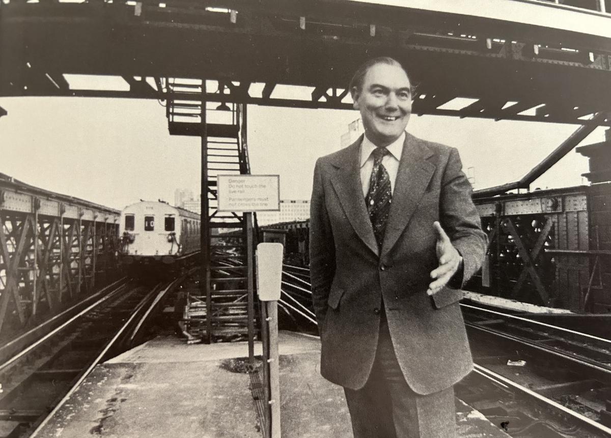 Black and white image of Sir Peter Parker at a train station